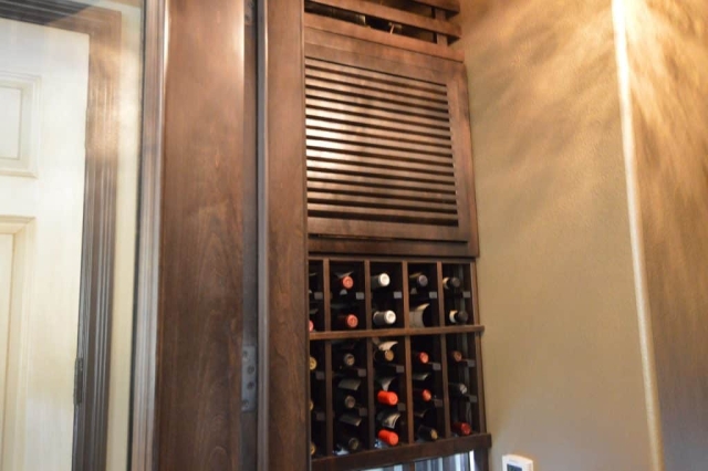 The split wine cellar cooling system is built behind a wooden cabinet, which helps absorbs the noise from the cooling unit.